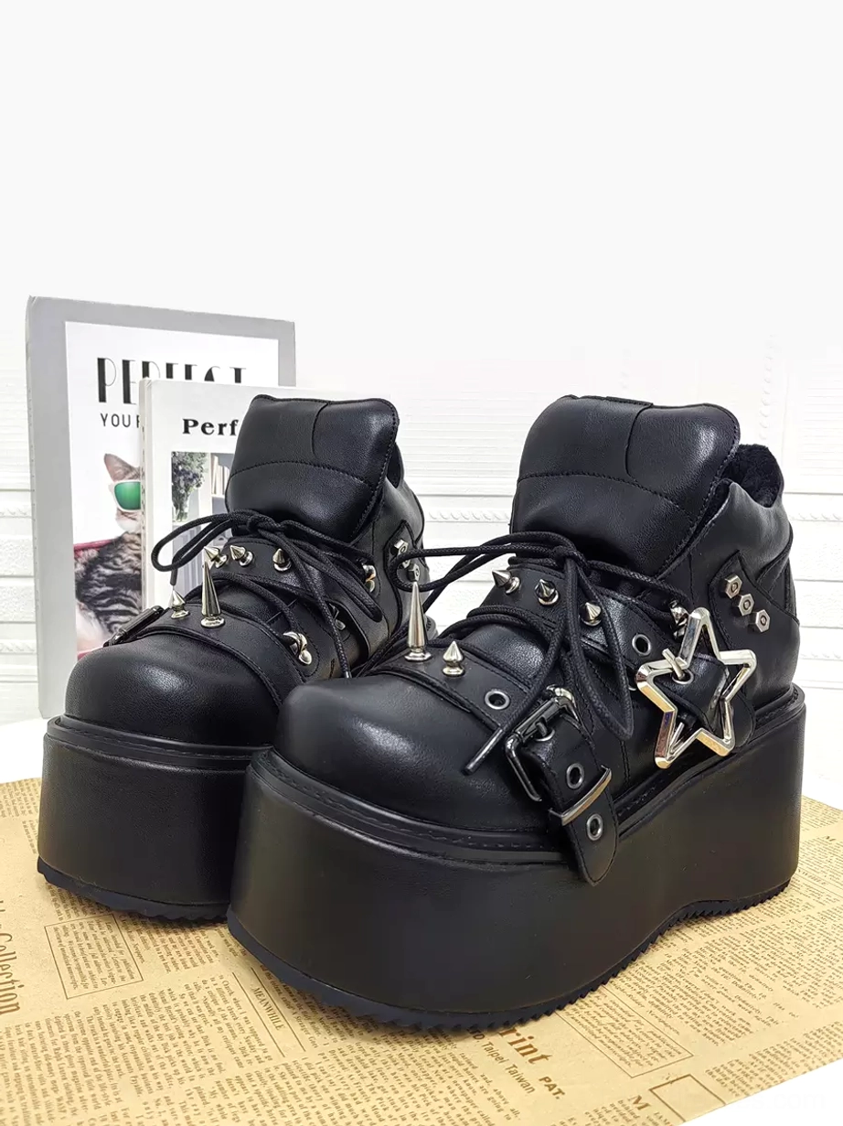 Paired punk lolita platform shoes close-up front view black leather upper silver star buckle spike accents heavy wedge sole
