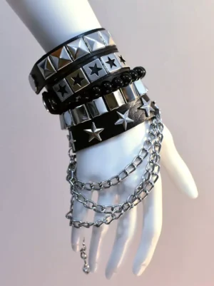 Stacked rivet punk bracelet collection featuring silver pyramid studs, star decorations, and dangling metal chains on black beaded band, front side view on white mannequin hand for lolita fashion