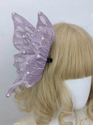 Purple butterfly lace hair clip with pearl decorations and black metal fastener worn on mannequin with blonde curly wig, side profile showing sheer lace construction