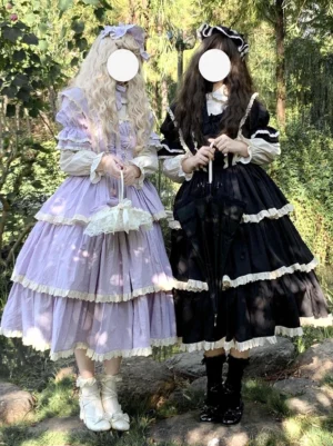 Purple gothic fairy lolita dress with tiered ruffles and white lace trim front view worn by female model in outdoor forest setting