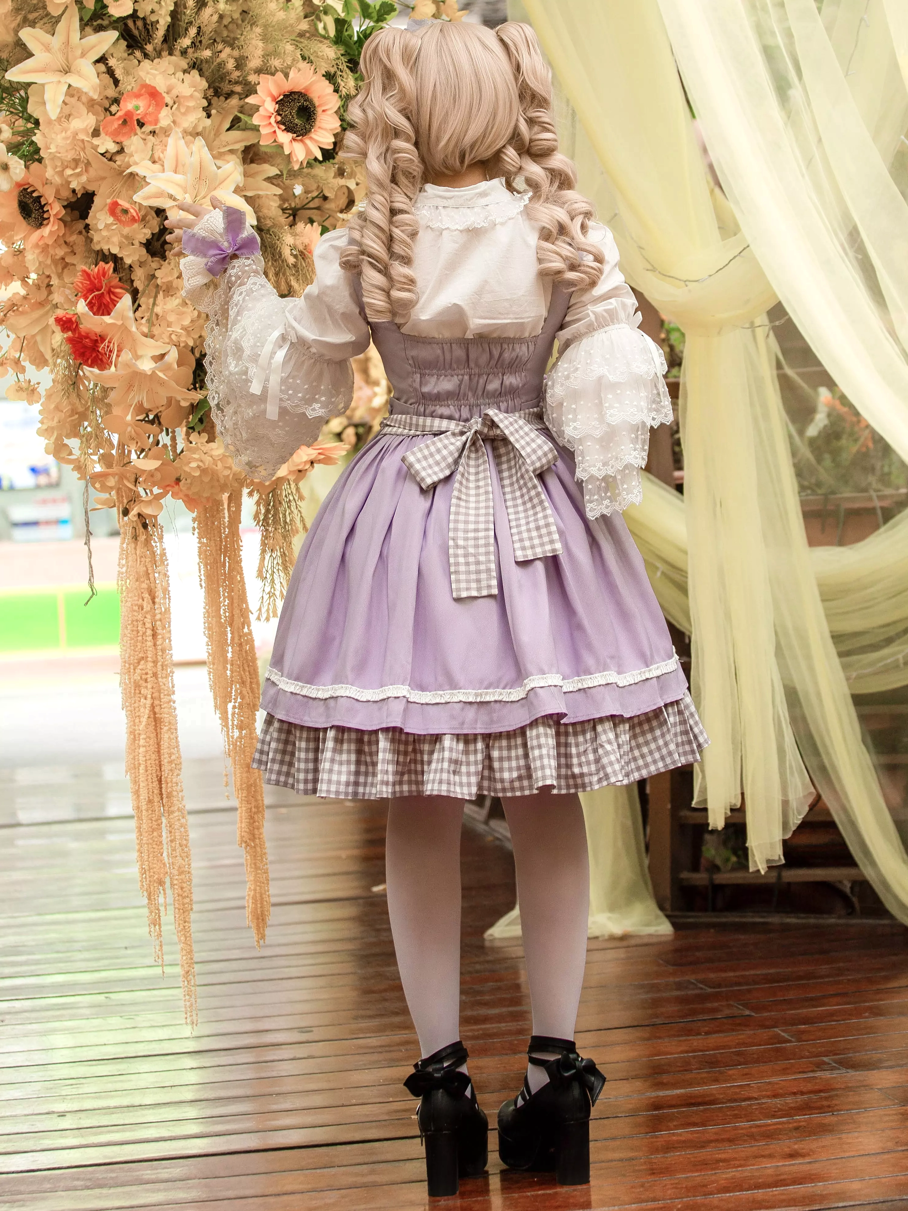 Purple violin lolita dress back view showing back bow sash gingham ruffled hem and adjustable shoulder straps