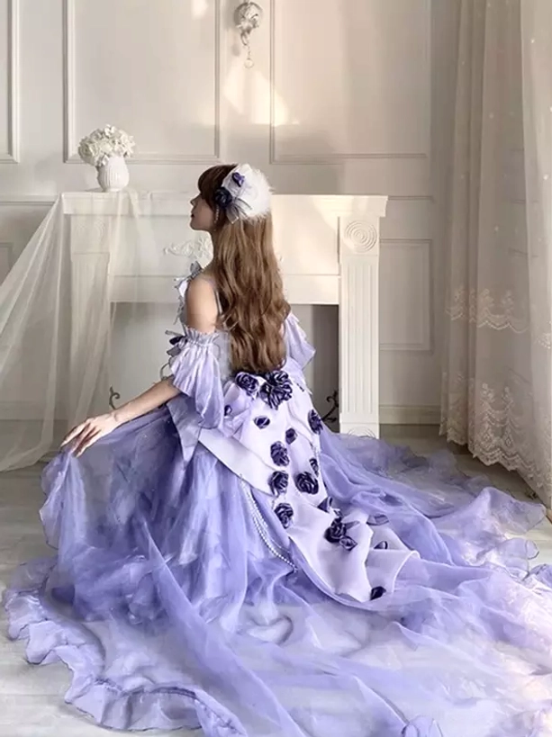 Side back sitting view of purple sweet lolita fairy dress showing long sweeping tulle train and dark rose appliqué details