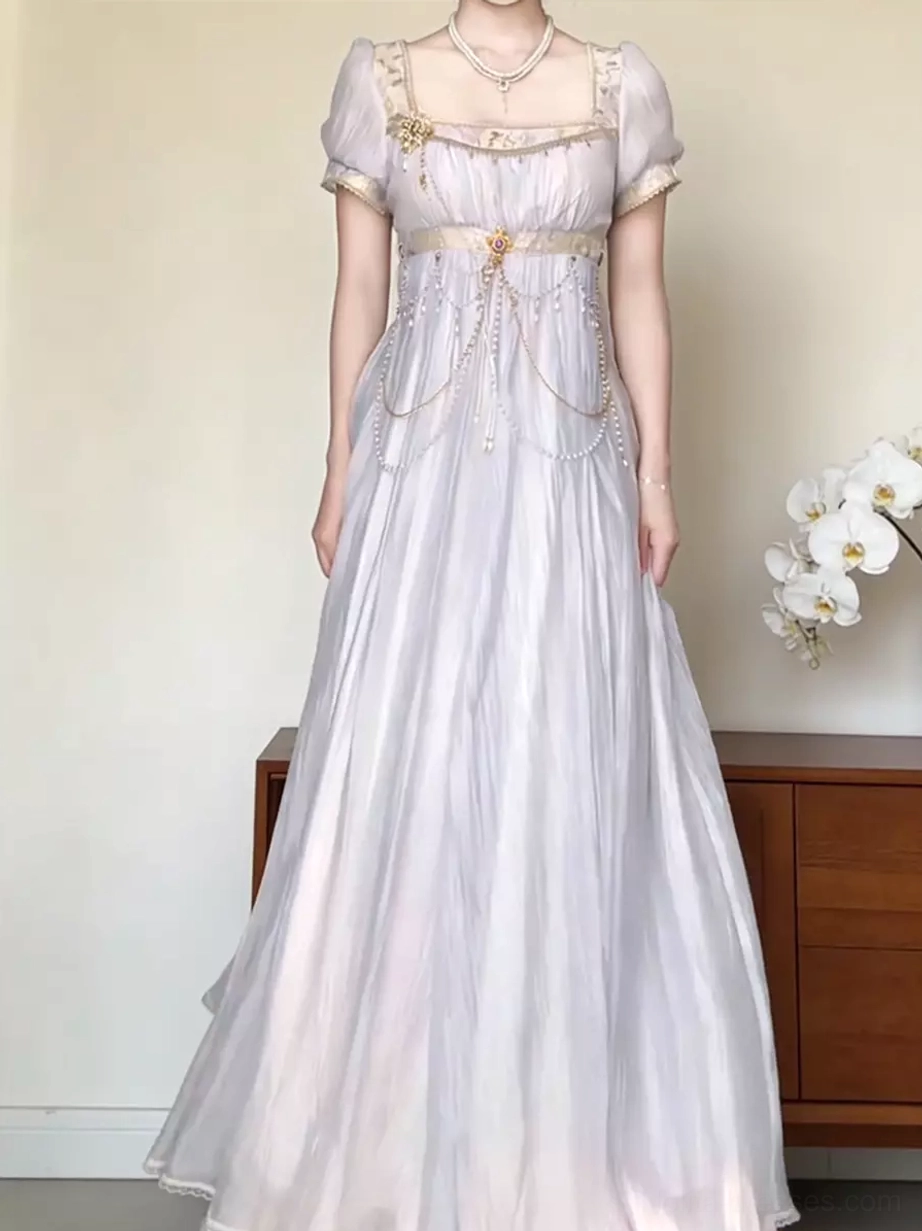 Full body front shot of lavender Lolita Regency gown with short puff sleeves, sheer wrinkled fabric, empire waist with chains, pearl necklace accessory, indoor setting