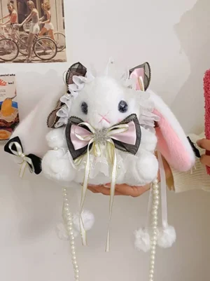 Black pink white plush rabbit lolita bag with dangling pearl tassels and ruffled lace trim, held in hand front view, kawaii accessories