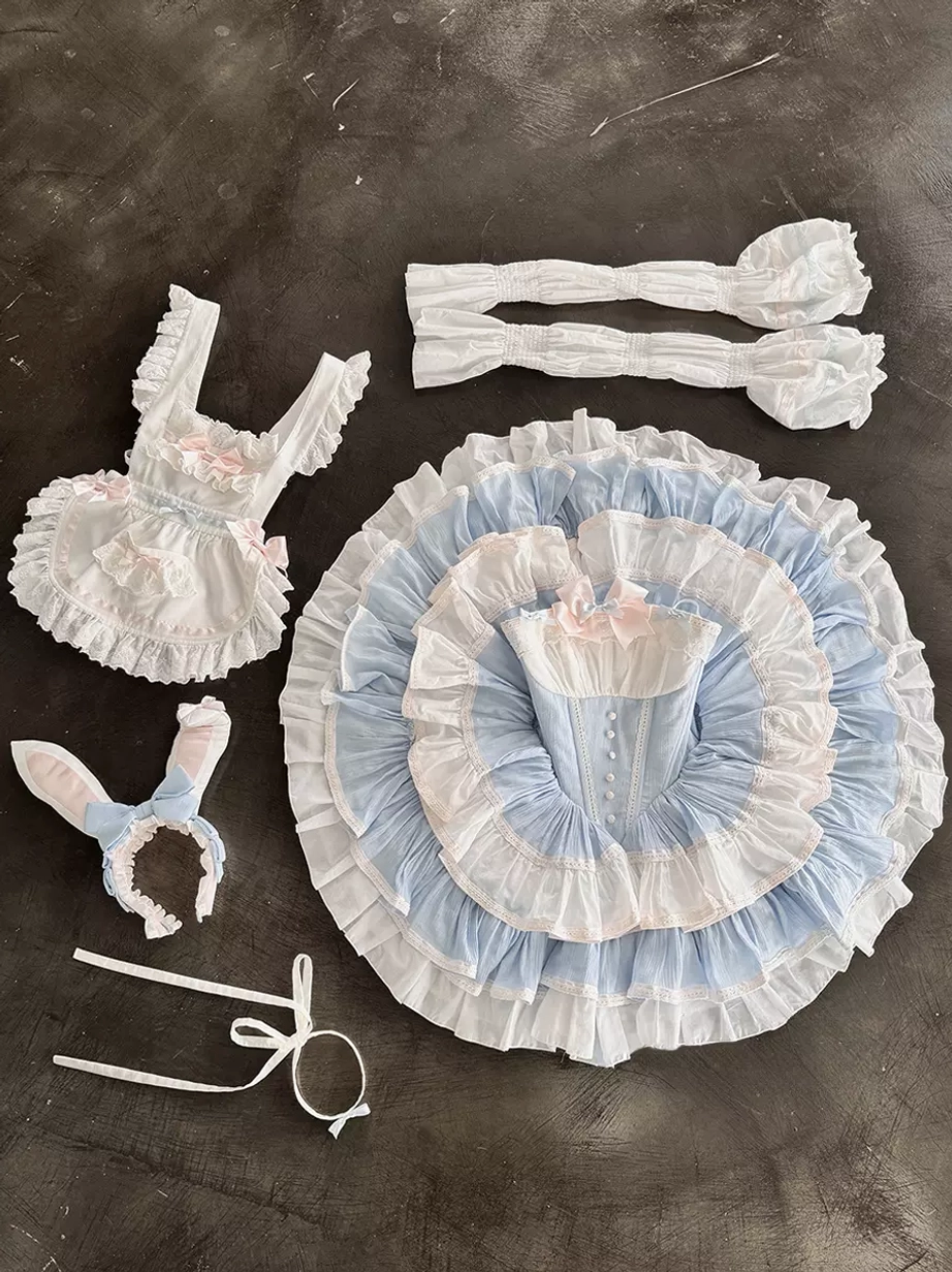 Flat lay display of separated rabbit maid lolita dress components including bodice, tiered skirt, detachable long sleeves, bunny ear headband, choker, apron, and ribbon ties