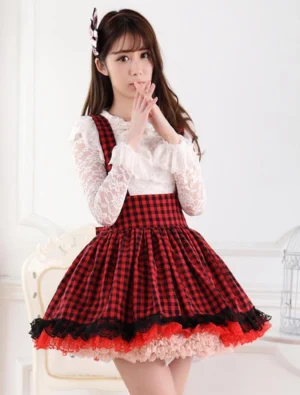 Red and black gingham sweet lolita suspender skirt salopette front three-quarter view paired with white lace blouse showing layered ruffled hem and elegant silhouette