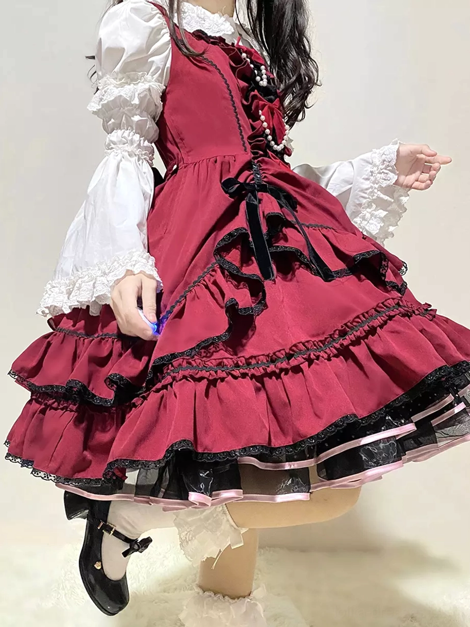 Red-black Sweet Lolita dress side partial view with tiered ruffled hem black lace and prominent front black bow