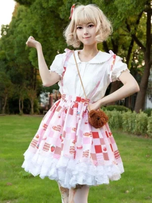 Red floral print lolita suspender skirt front view three-quarter angle outdoor lawn setting blonde model wearing matching hair bow dessert check print