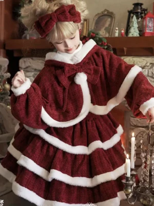 Close-up front shot of Christmas lolita cape and dress with wide lantern sleeves pompom bow accent and fireplace themed studio background