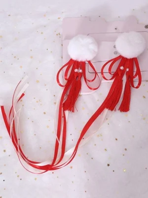 Flat lay pair of red Lolita hair accessories with white fluffy pom-poms, red tassels, and pearl decorations on pink starry background with product display card, perfect for styling your Lolita coordinate
