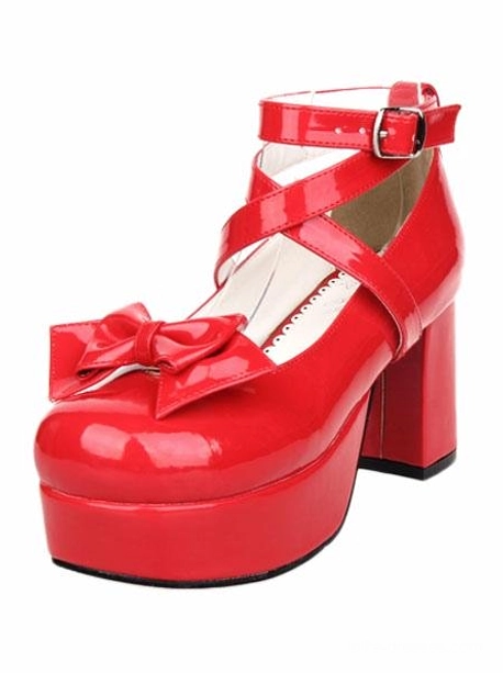 Single red lolita platform heel shoe left front three-quarter view, showing patent leather material, buckled cross ankle strap, decorative bow, and chunky platform heel