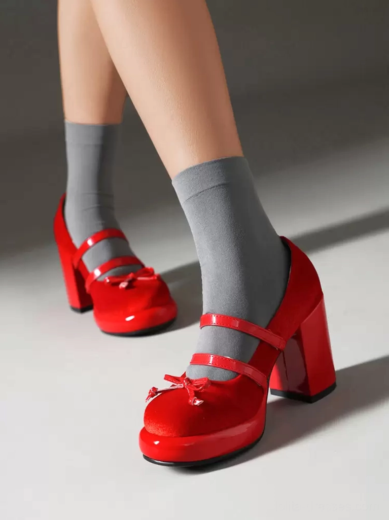 Red Lolita platform pumps front three-quarter angle showing thick block heel metal strap trim and front bow decoration