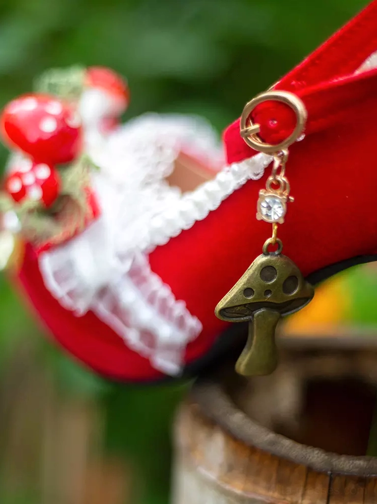 single red lolita heel shoe side close-up outdoor green foliage background metal mushroom pendant lace ruffle trim red mushroom appliques