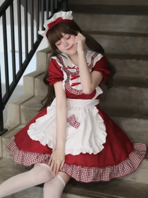 Red maid lolita dress with white ruffled apron three-quarter seated view short puff sleeves headpiece