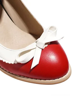 Vintage red Mary Jane dress pumps close-up top-down view, featuring white bow embellishment, scalloped trim details, and glossy PU leather texture