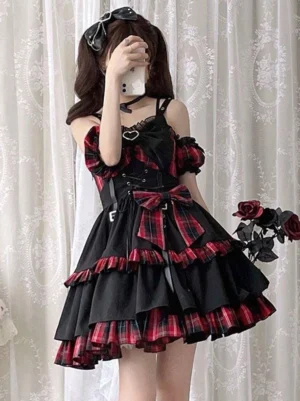 Red plaid gothic lolita jumper skirt full front view with ruffled trims and corset waist design on model with lace curtain backdrop