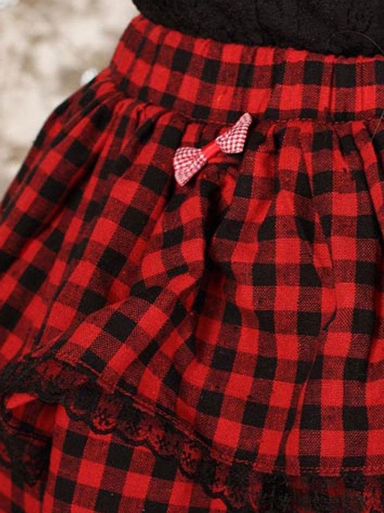 Close-up detail of red black buffalo plaid lolita skirt fabric texture black lace ruffle hem and coordinating plaid bow