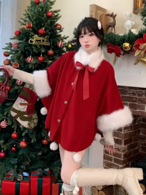 Red Sweet Lolita Christmas cape coat three-quarter view on model beside decorated Christmas tree with white knee-high boots fuzzy cuffs hem pom poms