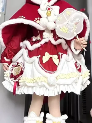 Red Sweet Lolita Christmas dress set front view with white fur-trimmed hooded cape, cat paw embroidery, cream ruffled details, and decorative bows worn by model holding embroidered fan
