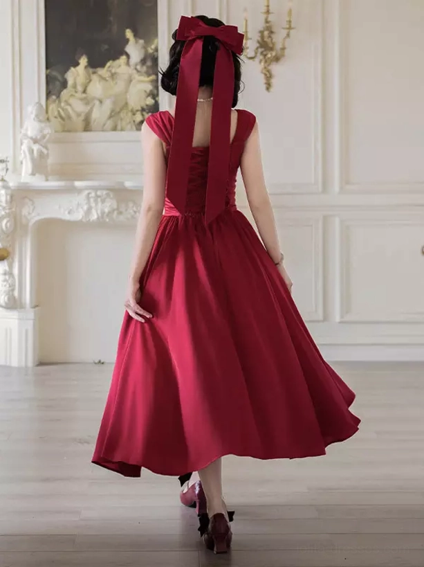 Red sweet Lolita dress back view featuring large decorative bow and long shoulder sash with flared midi skirt and ruffled details