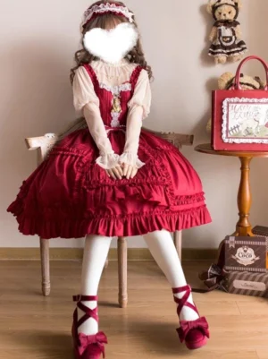 Red sweet lolita jumper dress sitting pose showing ruffled hem and lace-trimmed bodice detail