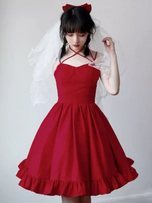 Red sweet lolita halter slip dress with sweetheart neckline and ruffled A-line skirt front view on model wearing hair bow and wedding veil light background