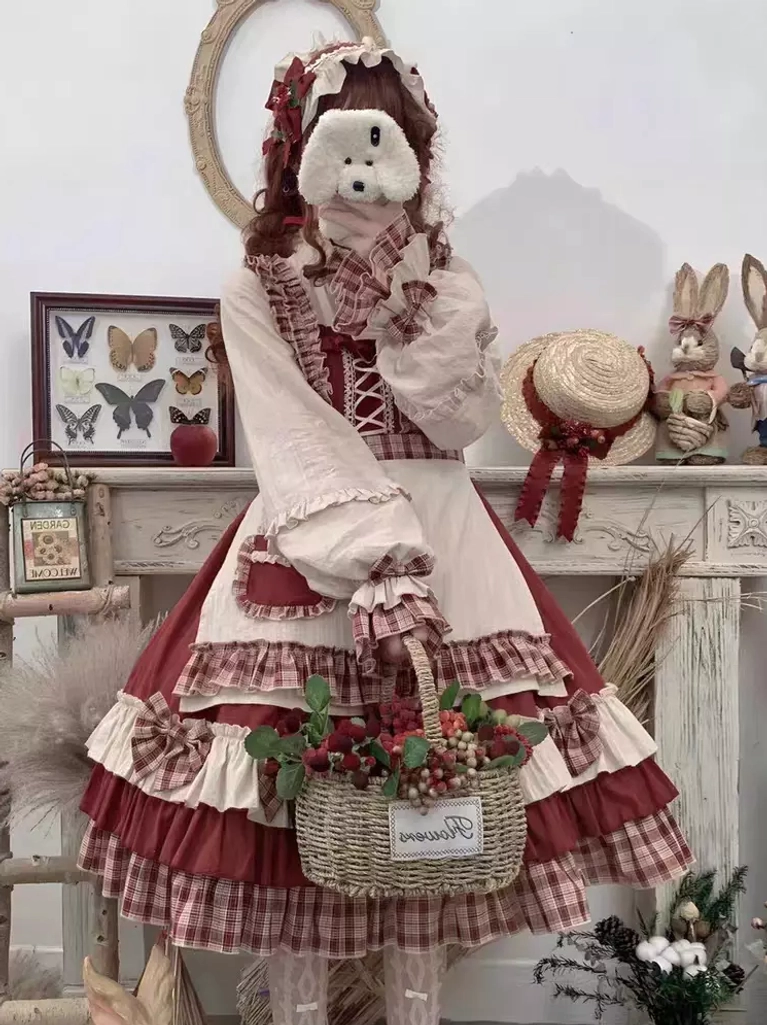Red sweet Lolita dress without cape showing plaid skirt hem and floral hair decoration with bow accents