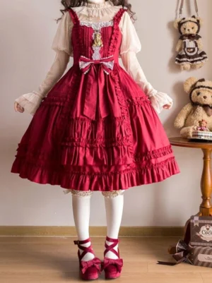 Red sleeveless sweet lolita jumper dress front view with tiered ruffled skirt lace neckline and front waist bow