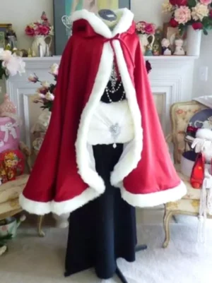 women's Christmas red velvet hooded cape cloak with white fuzzy edge front tie closure displayed on dress form vintage fireplace backdrop