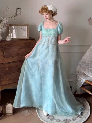 Mint green Regency empire waist fairy dress with square neckline, puff sleeves, and beaded chain waist accent, three-quarter front view on female model