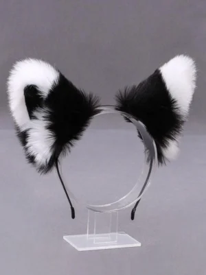 Monochrome reversible cat ear Lolita headband left front view, black and white dual-tone fluffy plush construction on clear acrylic display stand, gray studio background, showing dimensional ear design