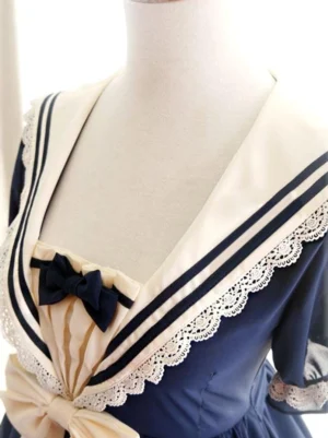 Close-up detail of sailor collar and neckline with navy stripe lace trim and black bow on Rhine lolita dress