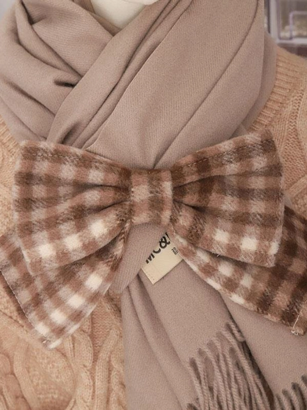 Flat lay close-up of brown gingham bow knitted lolita scarf with brand label detail and knit sweater styling context