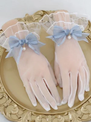 Light blue pearl bow sheer lolita gloves with ruffled cuffs shown on hand mannequins on gold tray display