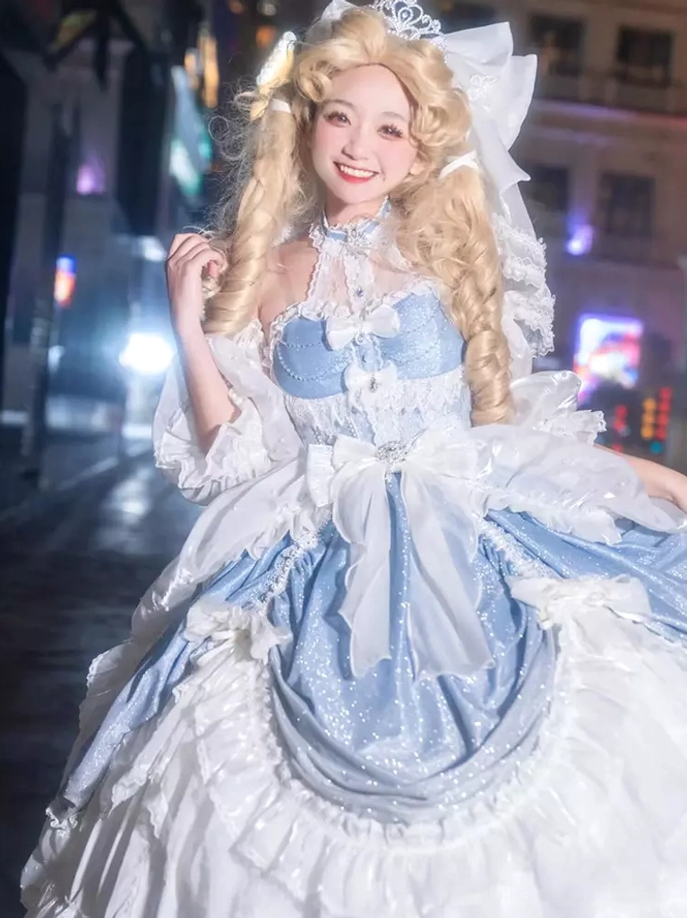 Close-up detail of light sky blue Rococo Lolita ball gown highlighting decorative tiara, halter neck, statement front bow, and delicate floral print textures