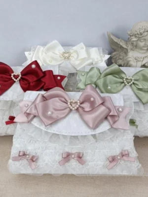 Rococo lolita handbag collection flat lay overhead view with white lace ruffles multi-color satin bows pearl embellishments vintage angel ornament