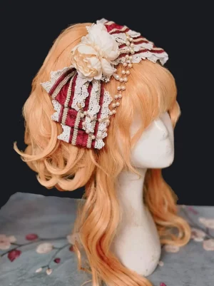 Rococo burgundy lolita head flower accessory with layered lace trim and artificial flowers, side three-quarter view on orange wig mannequin showcasing depth and dimensional design