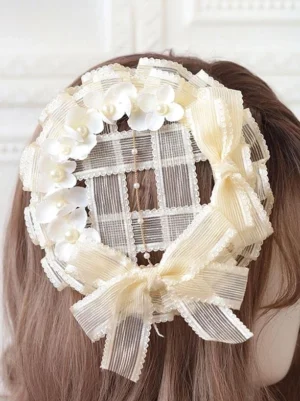 Rococo style lolita headdress with ecru grid mesh base, pearl-studded ivory flowers, and cascading bead tassels displayed on mannequin back view