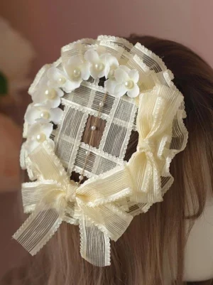 Sweet lolita rococo headdress side back profile showing beige ribbons, white floral embellishments, pearl accents and hanging bead tassel decorations