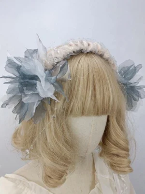 Rococo sweet lolita floral headband with gray-blue gradient organza flowers and ruched headband featuring beaded tassels, left three-quarter view on blonde mannequin