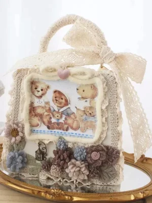 Rococo teddy bear lolita handbag coffee brown front oblique view with beige lace bow and fabric flowers on golden display tray
