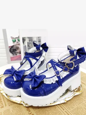 Royal blue sweet lolita platform pumps with white lace trim and heart-shaped buckle straps displayed on vintage newspaper with gilded tray and cat poster