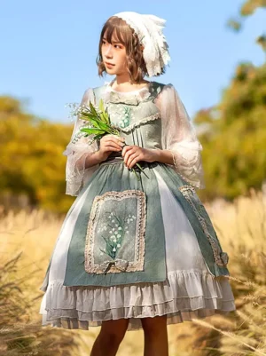 Sage green and white sweet lolita dress with lily of the valley embroidery worn outdoors in grassland, featuring sheer puff sleeves and lace-trimmed ruffled hem