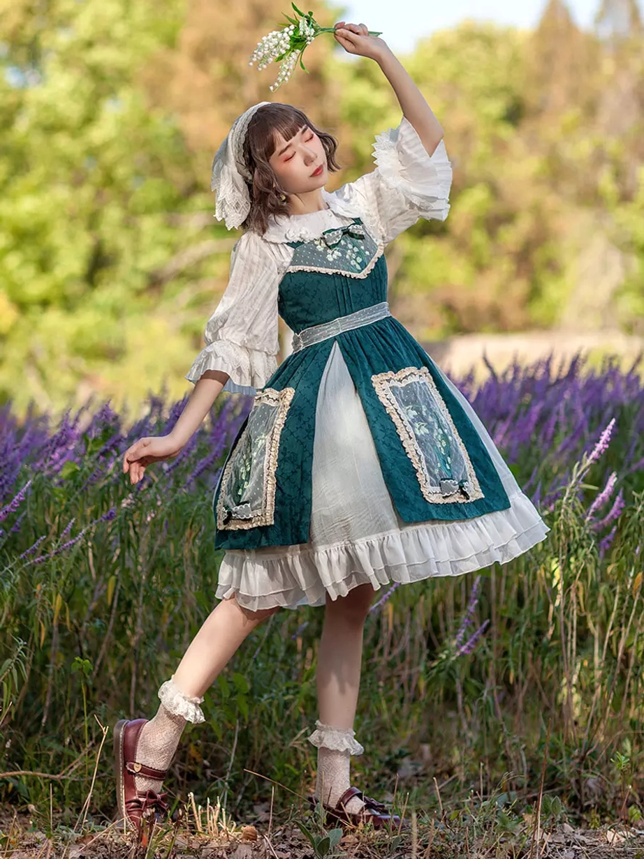 Low angle side view of sleeveless lolita dress in lavender field showing A-line silhouette, lace frilled socks, and leather mary jane shoes