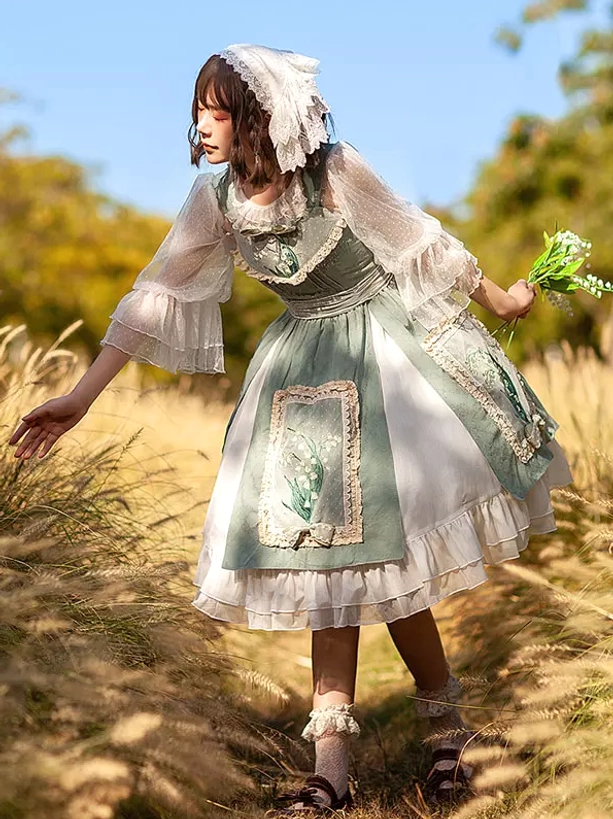 Front side angle of sage and white sweet lolita dress in wheat field with sheer puff sleeves and lily of the valley embroidery detail