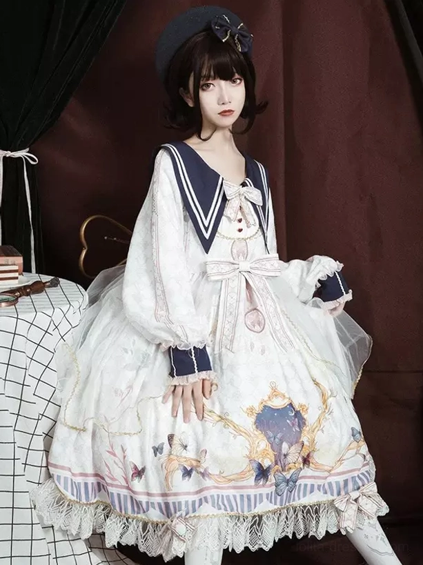 Navy sailor lolita academic dress detail shot showing butterfly print fabric, lace embellishment, bowknot decoration, and texture