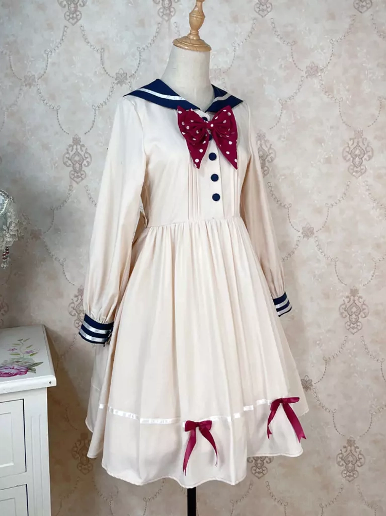 Classic sailor lolita dress beige with navy collar red bow tie ribbon hem detail vintage background mannequin display