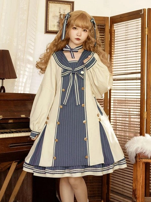 Front full-body view of cream and navy sailor sweet lolita dress with bow embellishments, long puff sleeves, and navy striped panels, worn by model with curly blonde hair and matching hair bows in vintage piano room setting