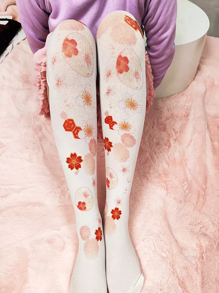 Sakura thigh-high lolita socks close-up view showing cherry blossom and fish-shaped decorative prints on white sheer material seated pose