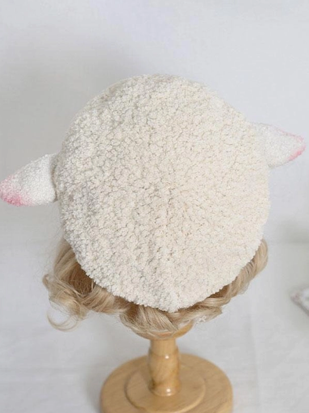Back overhead view of round plush off-white lolita beret with two pink-tipped sheep ears displayed on wooden stand, kawaii lolita fashion headdress back perspective